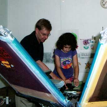 Brad Carlson teaching a young girlscout to screen print her own design.